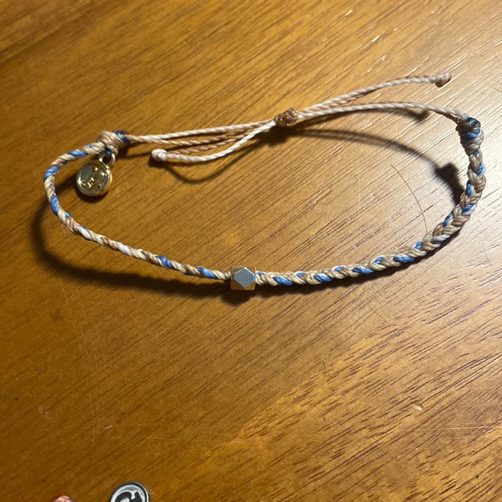 Braided pura vida bracelet with gold bead in the middle